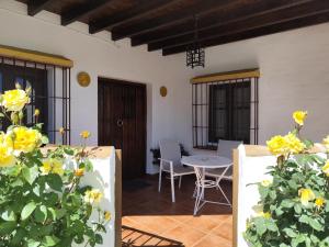 a patio with yellow flowers and a table and chairs at Casa Villazo 2 in Málaga