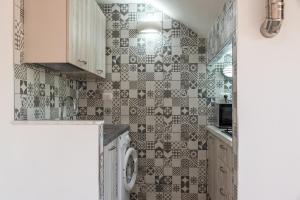 a kitchen with a washer and dryer on the wall at Monolocale Arredato - Le Terrazze in Ribera +19 photos
