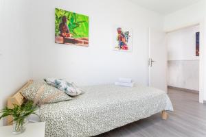 a white bedroom with a bed and some pictures on the wall at Villa Candelaria in La Matanza de Acentejo