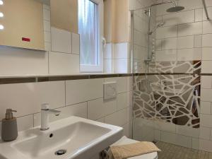 a bathroom with a sink and a shower at Ferienhaus Eichelhäher in Zossen +36 photos