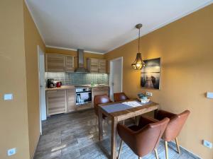 a kitchen with a dining room table and chairs at Ferienhaus Eichelhäher in Zossen