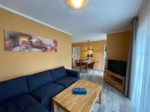 a living room with a blue couch and a table at Ferienhaus Eichelhäher in Zossen