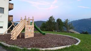 a wooden playground with a slide in a yard at Forchnerhof Apt Rose in Maranza