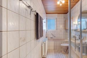 a bathroom with a toilet and a tub and a sink at Ferienwohnung Huckelberg in Schmallenberg +17 photos