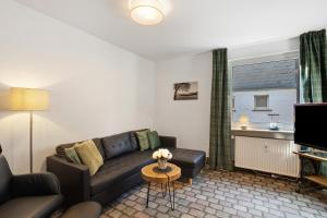 a living room with a couch and a television at Ferienwohnung Huckelberg in Schmallenberg