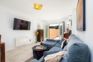 a living room with a blue couch and a tv at Apartamento La Pergola in Font de Sa Cala