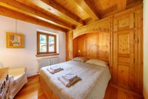 a bedroom with a large bed with wooden walls at Casa San Giovanni 2 a Vinigo in Vinigo