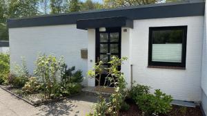 a white house with a black roof and a window at Ferienwohnung Strandgut in Glücksburg