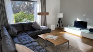 a living room with a leather couch and a table at Ferienwohnung Strandgut in Glücksburg
