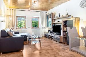 a living room with a couch and a tv at Landhaus Echerschwang in Bernbeuren