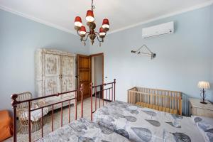 a bedroom with a bed and a chandelier at Appartamento La Buraggia in Diano San Pietro
