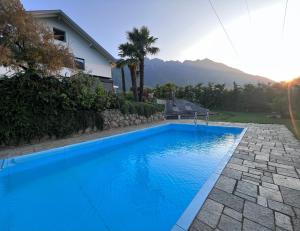 a large blue swimming pool in front of a house at Casa Sonngart in Parcines