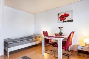 a room with a table and chairs and a bed at Szafranzimmervermietung in Winnenden