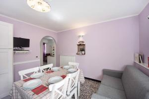 a dining room with a table and a couch at Appartamento La Buraggia in Diano San Pietro