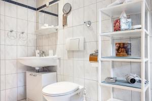 a white bathroom with a toilet and a sink at Landhaus Echerschwang in Bernbeuren +31 photos