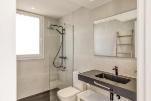 a bathroom with a sink and a toilet and a shower at Apartamento ático en L'Escala in L'Escala +20 photos