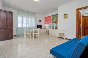a living room with a blue couch and a kitchen at Quadrilocale Via D'annunzio in San Teodoro +12 photos