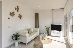 a living room with a couch and a tv at Apartamento ático en L'Escala in L'Escala