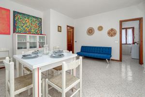 a dining room with a white table and a blue couch at Quadrilocale Via D'annunzio in San Teodoro