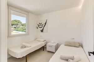 two beds in a room with a window at Apartamento ático en L'Escala in L'Escala