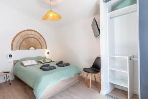 a small bedroom with a bed and a chair at La Goisette in Beauvoir-sur-Mer