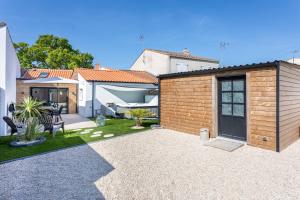a garden with a brick building and a patio at La Goisette in Beauvoir-sur-Mer