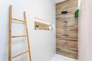 a bathroom with a shower with a wooden wall at La Goisette in Beauvoir-sur-Mer +24 photos