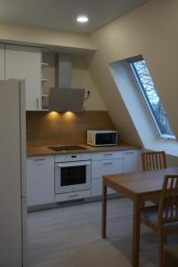a kitchen with a stove and a table and a window at Kaiju Apartment 15 in Liepāja