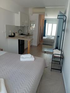 a room with a bed and a kitchen with a sink at Nice & cosy central studios in Mikonos +9 photos