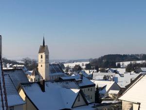a town with snow covered roofs and a church at Ferienwohnung Haus Maria in Wäschenbeuren