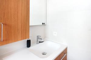 ein Badezimmer mit einem weißen Waschbecken und einem Holzschrank in der Unterkunft Maison Aranea in Ascain