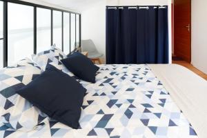 ein Schlafzimmer mit einem Bett mit blau-weißen Kissen in der Unterkunft Maison Aranea in Ascain