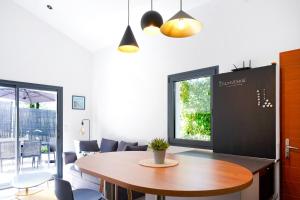 ein Esszimmer mit einem Tisch und einem großen Fenster in der Unterkunft Maison Aranea in Ascain + 16 Fotos