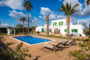 a villa with a swimming pool and palm trees at Finca Goet in Sa Pobla