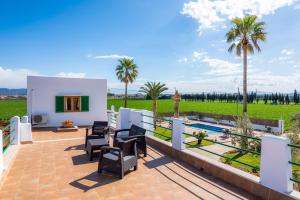 a villa with a swimming pool and palm trees at Finca Goet in Sa Pobla