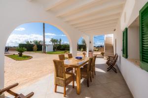 a dining room with a table and chairs on a patio at Finca Goet in Sa Pobla