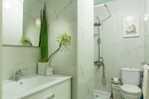 a white bathroom with a toilet and a sink at Flamingo Rosa in Arinaga