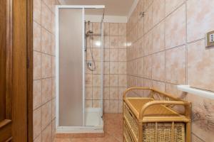 un bagno con doccia e cesto di vimini di Appartamento Chia A a Chia Altre 16 foto