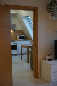 a kitchen with a table and a kitchen under a roof at Kaiju Apartment 15 in Liepāja +14 photos