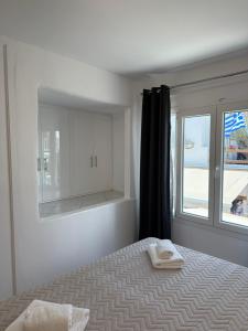 a bedroom with a bed with a mirror and a window at Nice & cosy central studios in Mikonos
