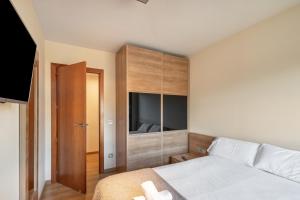 a bedroom with a bed and a cabinet with a television at Niu Turistic Olvan in Olvan