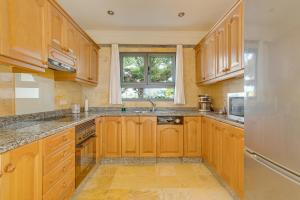 a large kitchen with wooden cabinets and a window at Villa Capricho in Lanzarote