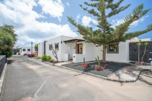 a house with a palm tree in the driveway at Villa Capricho in Lanzarote