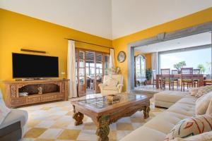 a living room with a flat screen tv and a table at Villa Capricho in Lanzarote