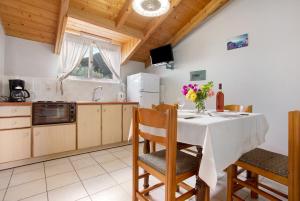 a kitchen with a table with a vase of flowers on it at Dolphin Apartment Sea View 9 in Keri +18 photos