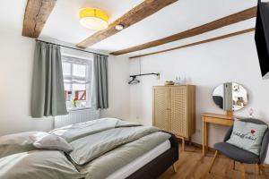 a bedroom with a bed and a desk and a mirror at Zeihäänger Stubb in Schwalmstadt