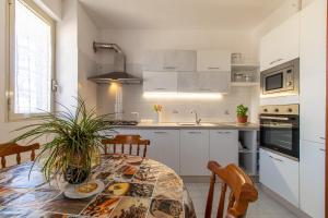 a kitchen with a table and a kitchen with white cabinets at Casa Riviera in Donnalucata +16 photos