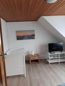 a living room with a tv and a table at Bei Heike 1 in Zetel