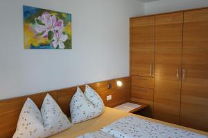 a bedroom with a bed with pillows and a cabinet at Waalhof Ferienwohnung Apfelblüte in Silandro
