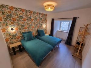a bedroom with a green bed and a window at L'Ecole Buissonnière de Mazalibrand in Mazet-Saint-Voy